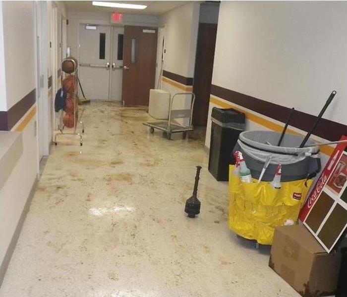 corridor showing sewage on floor, a maintenance cleaning set, and other items