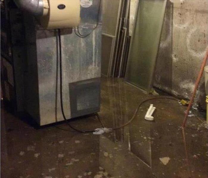 dirty floodwater by the furnace in a basement